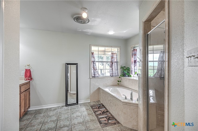 bathroom with vanity, a textured ceiling, and independent shower and bath