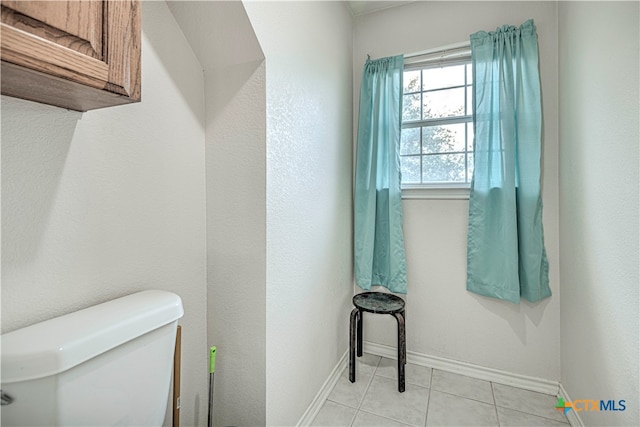 bathroom with toilet and tile patterned floors