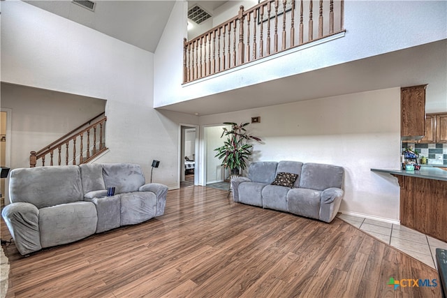 living room with high vaulted ceiling and wood-type flooring