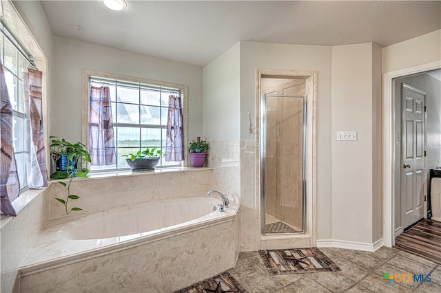 bathroom featuring shower with separate bathtub, a textured ceiling, and tile patterned floors