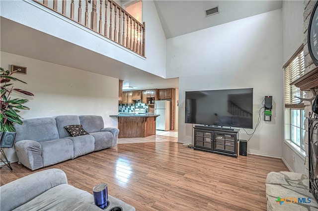 living room featuring a high ceiling and light wood-type flooring