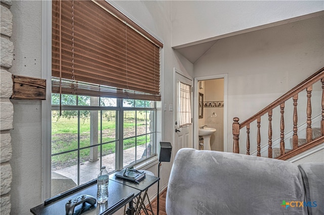 living room featuring hardwood / wood-style floors, lofted ceiling, and sink