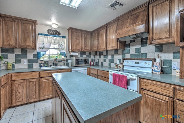 kitchen with light tile patterned flooring, sink, range with electric cooktop, a center island, and premium range hood