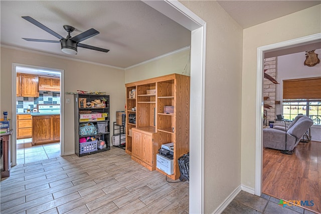 office area with light wood-type flooring, ceiling fan, and crown molding