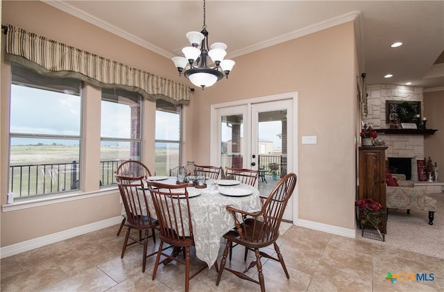 tiled dining space with a fireplace, an inviting chandelier, french doors, and ornamental molding