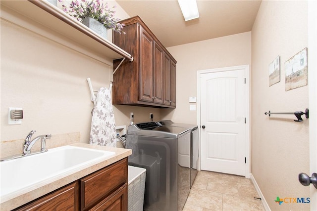 laundry area featuring washing machine and clothes dryer, sink, and cabinets