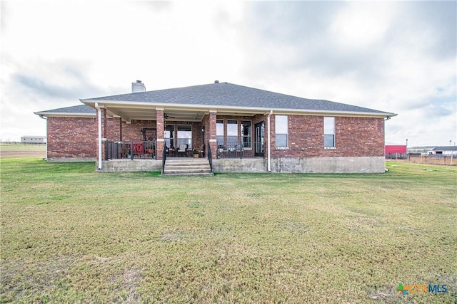 rear view of property with a lawn and a patio