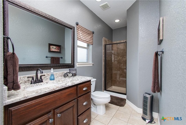 bathroom with tile patterned floors, vanity, toilet, and a shower with door