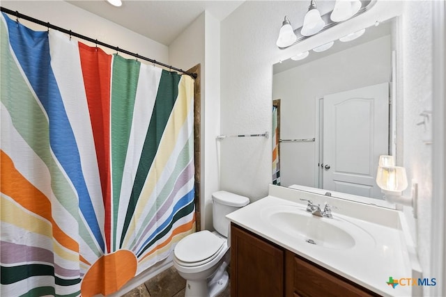 bathroom featuring toilet, curtained shower, and vanity