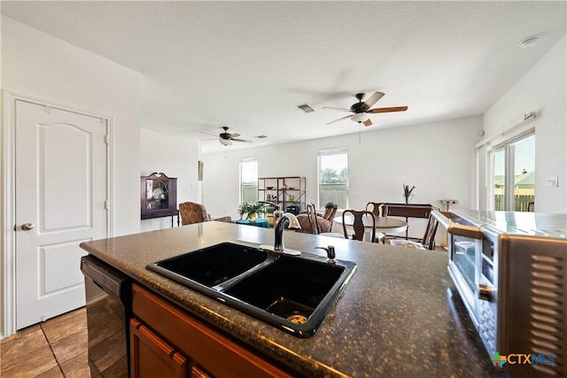 kitchen with a sink, visible vents, black dishwasher, open floor plan, and stainless steel microwave