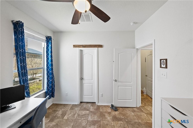 office space with a ceiling fan, visible vents, and baseboards