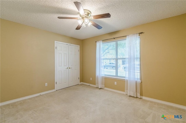 127 Maple Dr, Mountain City, TX 78610 - unfurnished bedroom with a textured ceiling, carpet floors, a closet, and ceiling fan