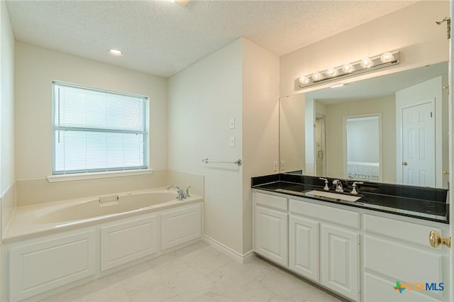 127 Maple Dr, Mountain City, TX 78610 - bathroom featuring a bath, vanity, a textured ceiling, and recessed lighting