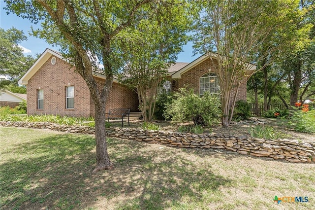 127 Maple Dr, Mountain City, TX 78610 - view of front of house with brick siding and a front yard