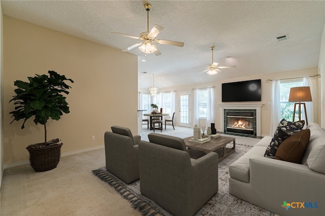 127 Maple Dr, Mountain City, TX 78610 - carpeted living room featuring healthy amount of natural light, a textured ceiling, a ceiling fan, lofted ceiling, and a fireplace