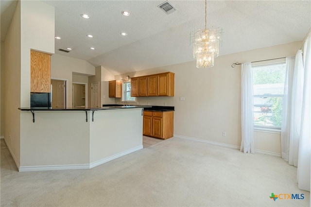 127 Maple Dr, Mountain City, TX 78610 - kitchen with dark countertops, light carpet, brown cabinets, lofted ceiling, and recessed lighting