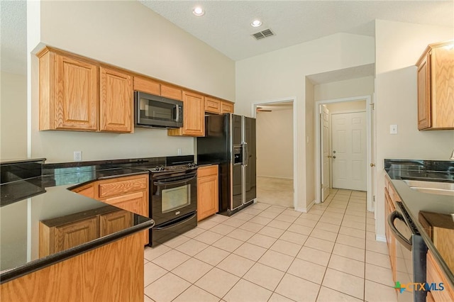 127 Maple Dr, Mountain City, TX 78610 - kitchen featuring black appliances, dark countertops, light tile patterned floors, and recessed lighting