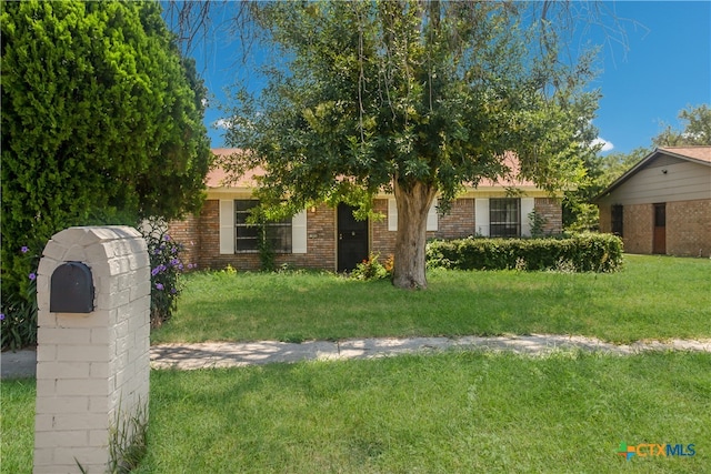 view of property hidden behind natural elements with a front yard