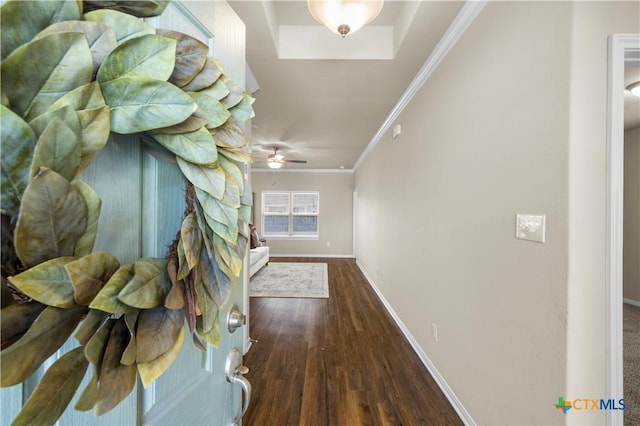 corridor with baseboards, ornamental molding, and dark wood-style flooring