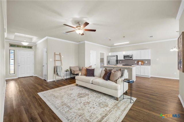 living area featuring dark wood-style floors, baseboards, and crown molding