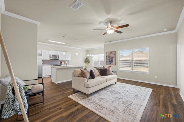 living area with visible vents, ornamental molding, dark wood finished floors, and baseboards