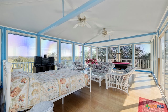 bedroom with hardwood / wood-style flooring, beamed ceiling, multiple windows, and ceiling fan