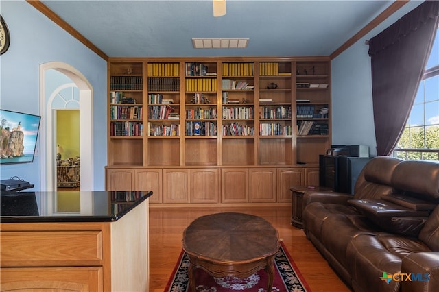 living area featuring light hardwood / wood-style floors and ornamental molding