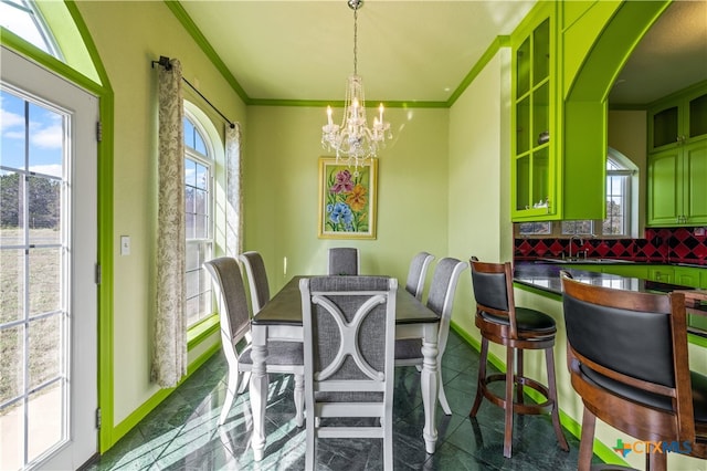 dining room with ornamental molding, a notable chandelier, and sink