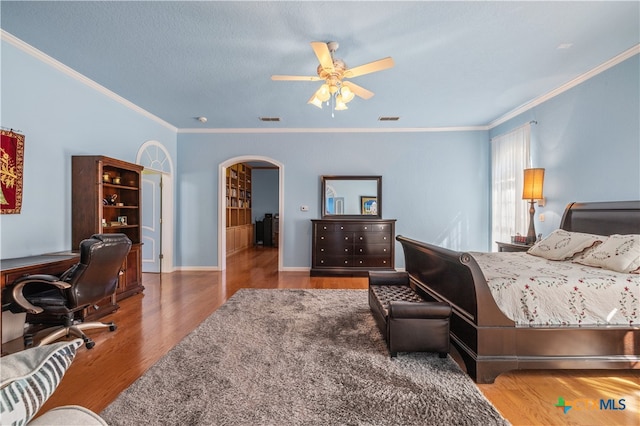 bedroom with ornamental molding, hardwood / wood-style floors, and ceiling fan