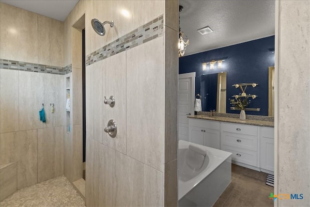 bathroom featuring vanity, shower with separate bathtub, and a textured ceiling