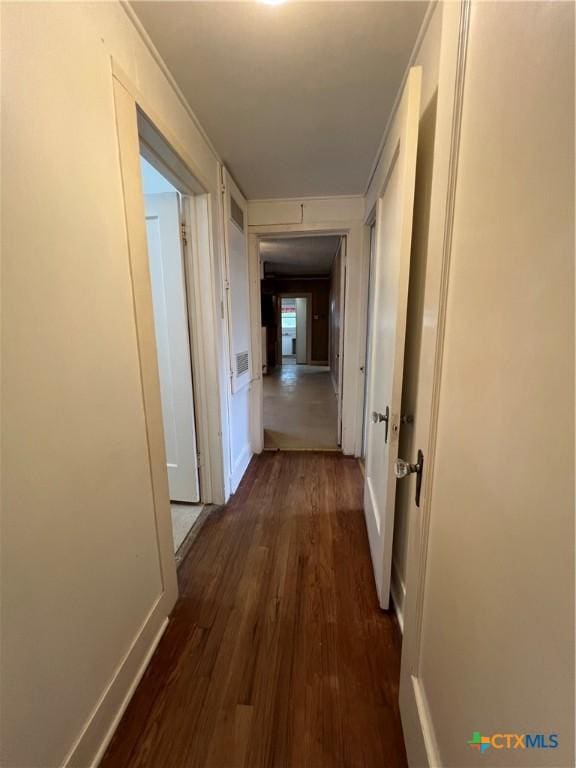 hall featuring crown molding, wood finished floors, and baseboards
