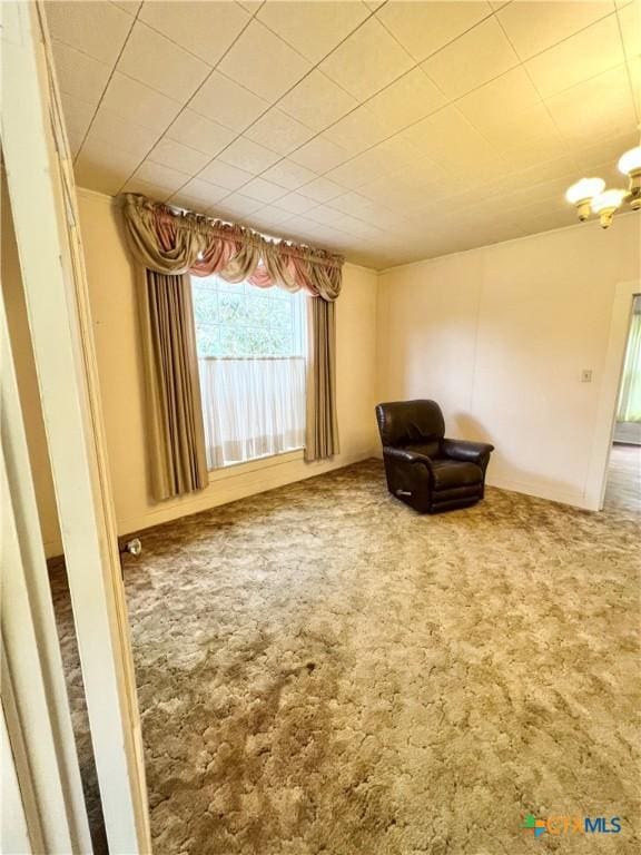 unfurnished room featuring an inviting chandelier and carpet