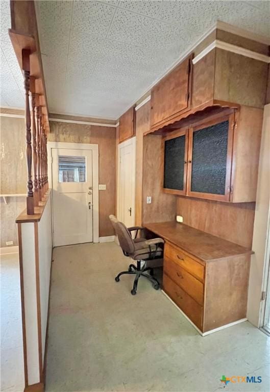 office area featuring built in desk and wooden walls