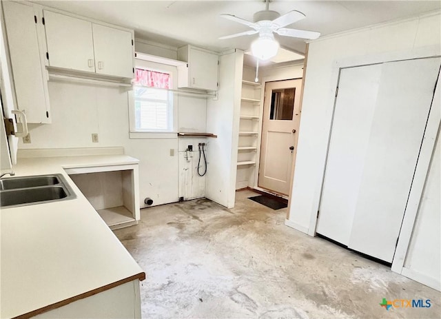 kitchen with ceiling fan, light countertops, concrete floors, and a sink