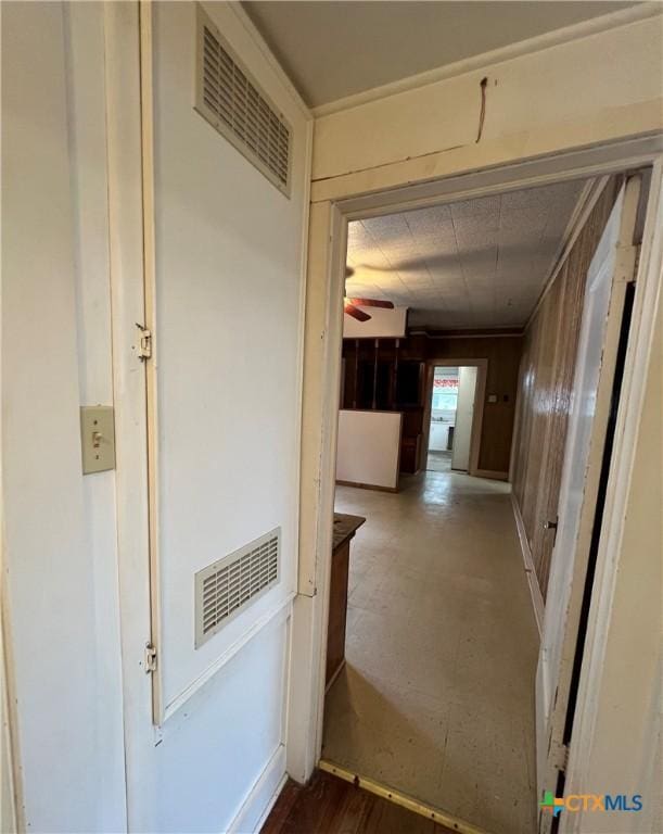 hall featuring wooden walls and visible vents
