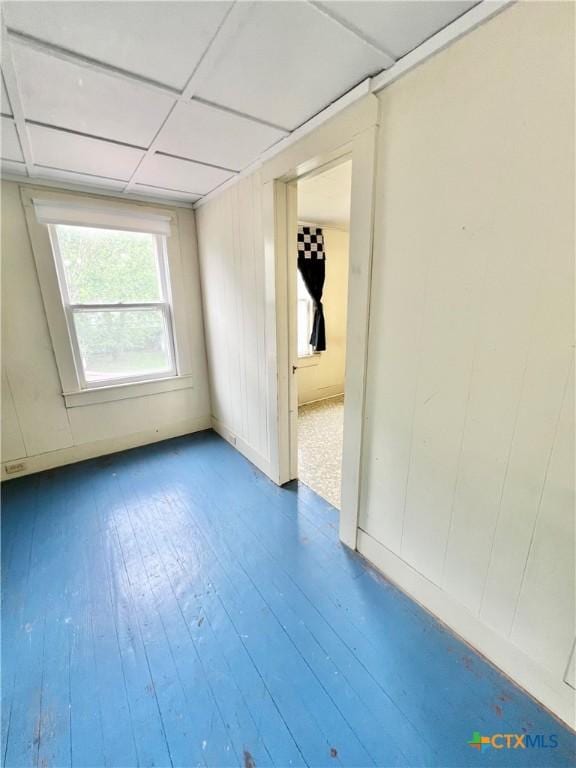 unfurnished room featuring a drop ceiling and hardwood / wood-style flooring