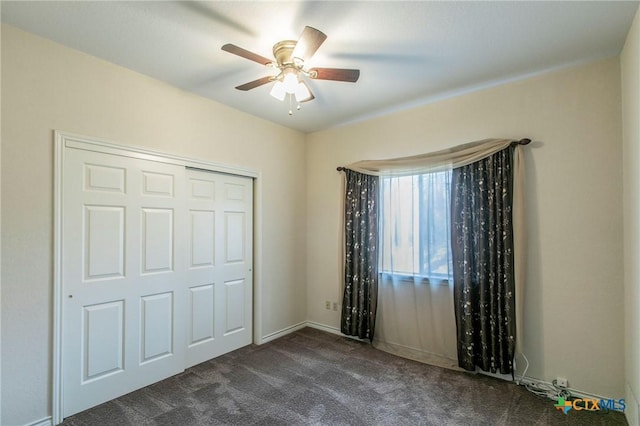 unfurnished bedroom with a closet, ceiling fan, and dark colored carpet