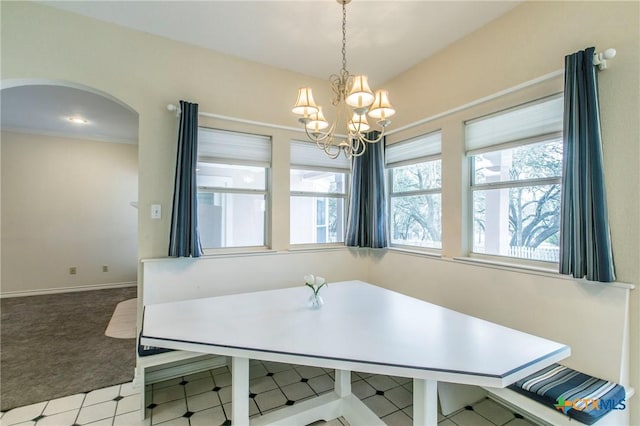 carpeted dining area featuring vaulted ceiling and a chandelier