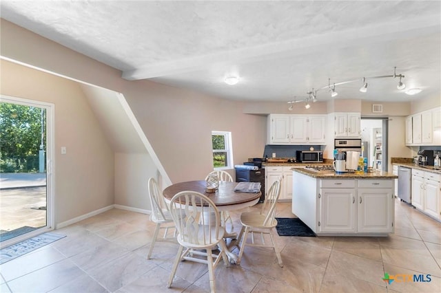 503 Rabbit Run Rd, Victoria, TX 77905 - kitchen with appliances with stainless steel finishes, a kitchen island, white cabinetry, and healthy amount of natural light