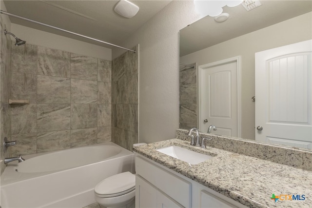 full bathroom with tiled shower / bath, toilet, and vanity