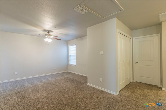 carpeted empty room with ceiling fan and a textured ceiling