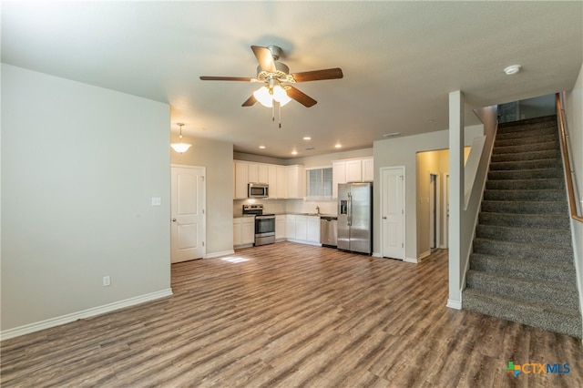 unfurnished living room with hardwood / wood-style floors, ceiling fan, and sink