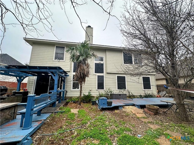 back of house with a pergola and a deck