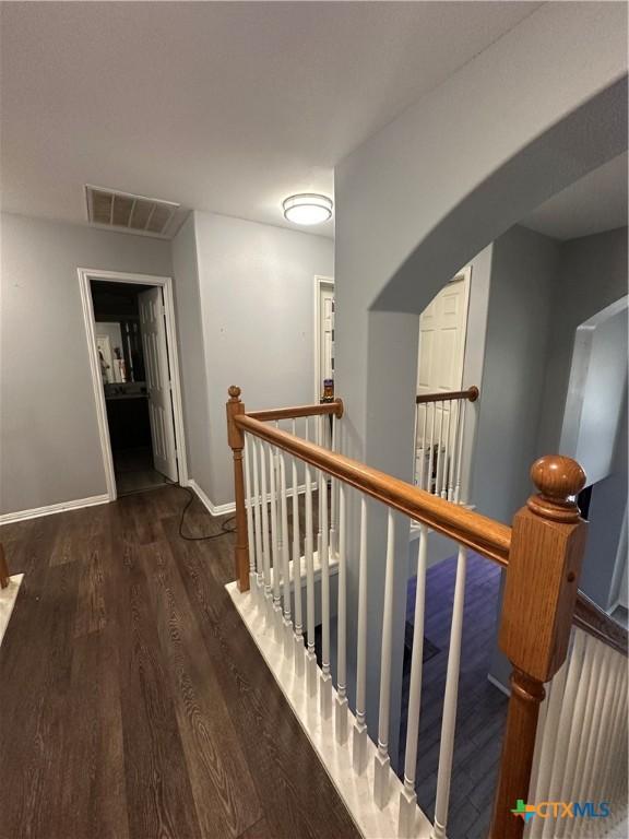 corridor with dark hardwood / wood-style flooring