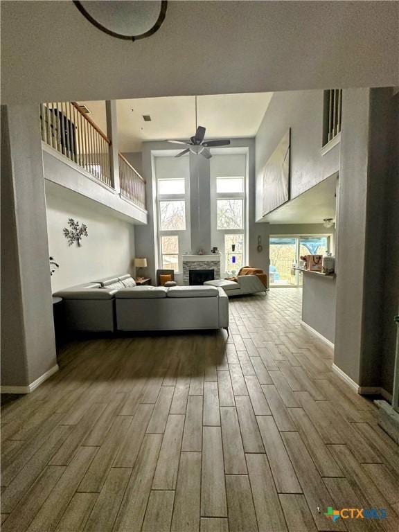 unfurnished living room featuring ceiling fan and a towering ceiling