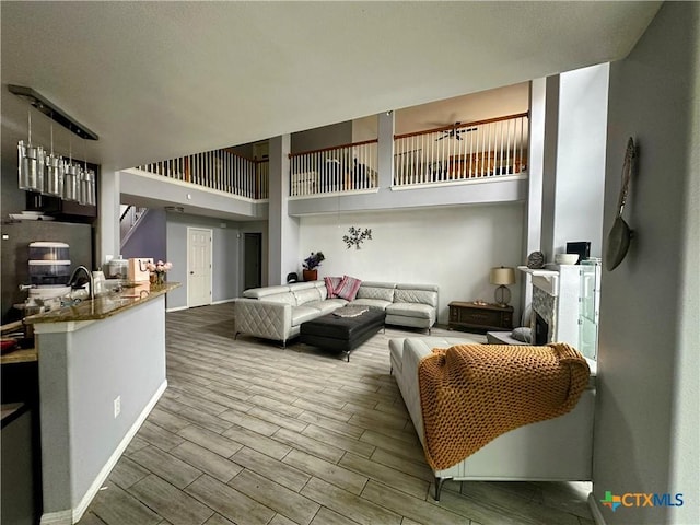 living room with a towering ceiling and a fireplace