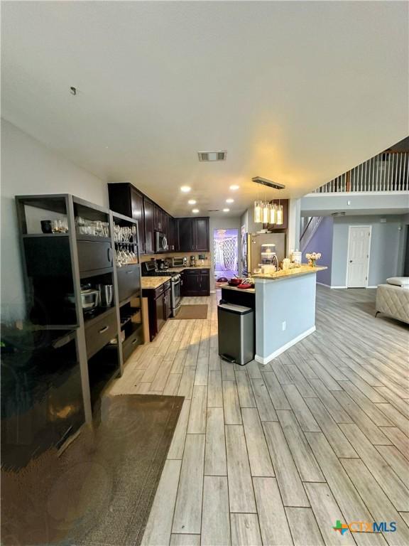 kitchen with dark brown cabinets, a center island, and appliances with stainless steel finishes