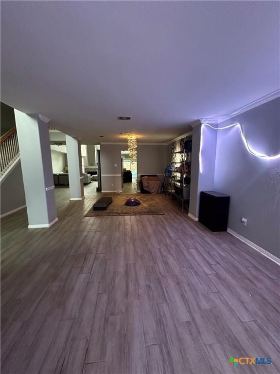 unfurnished living room featuring hardwood / wood-style flooring and crown molding