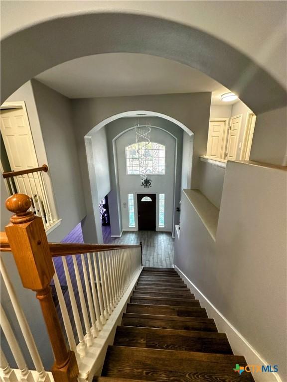 staircase featuring hardwood / wood-style floors and a notable chandelier