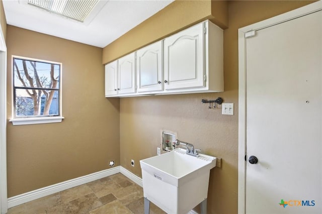 clothes washing area featuring a sink, visible vents, baseboards, hookup for a washing machine, and cabinet space